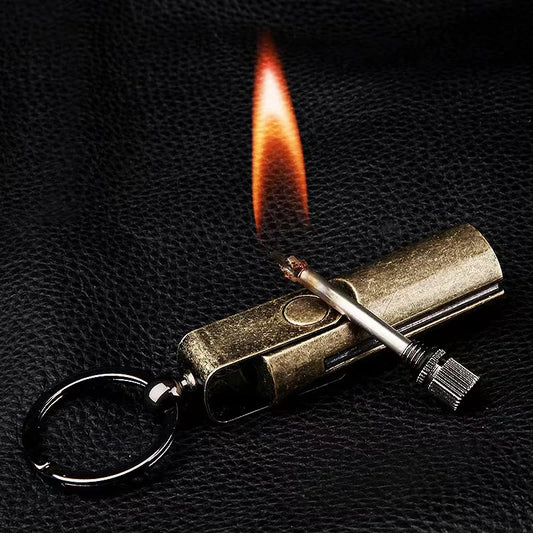 Antique bronze keychain permanent match lying open on black leather, its striker rod alight beside it