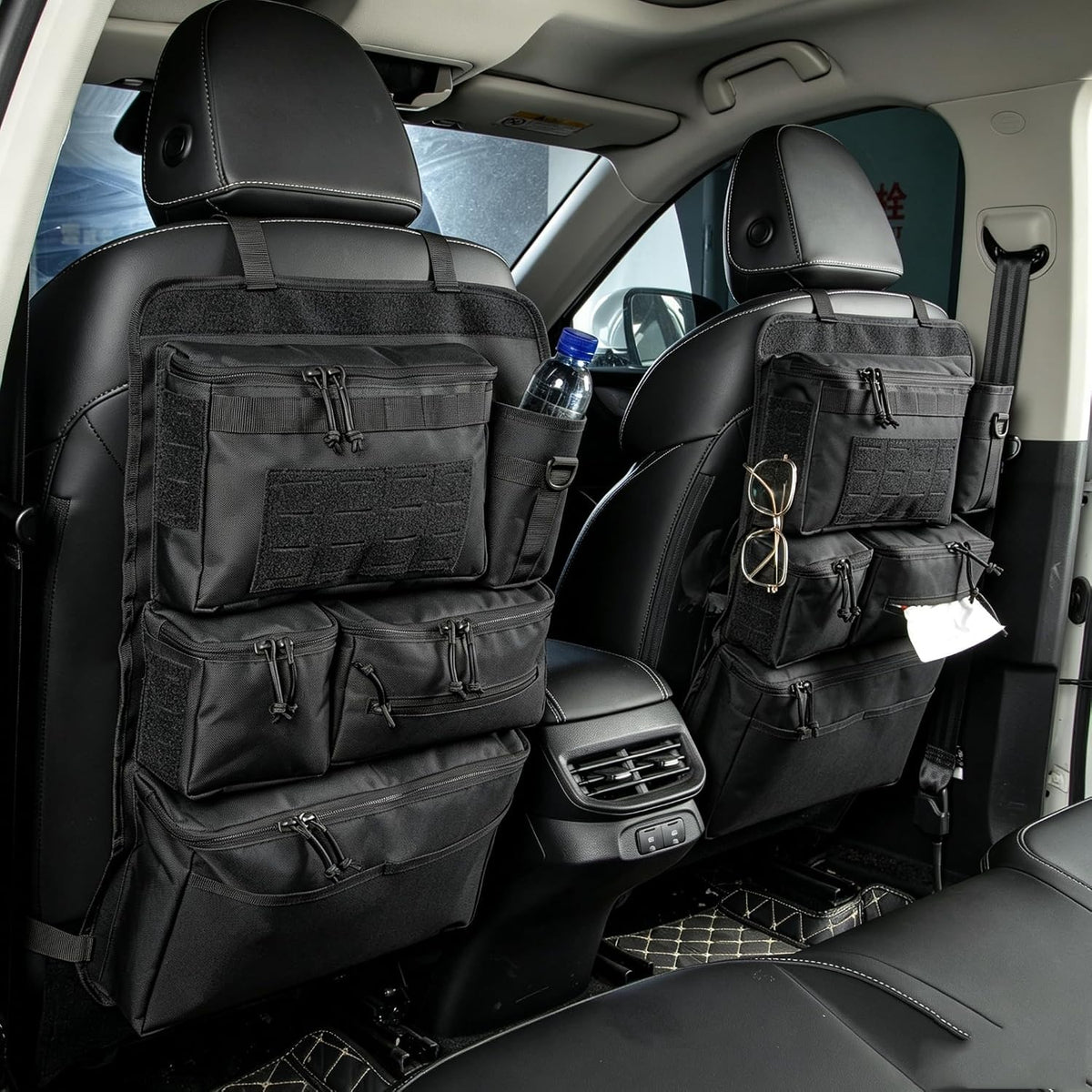 The organizer on a front seat inside a car, with a water bottle in the side pocket, glasses on the webbing and tissues in the document sleeve